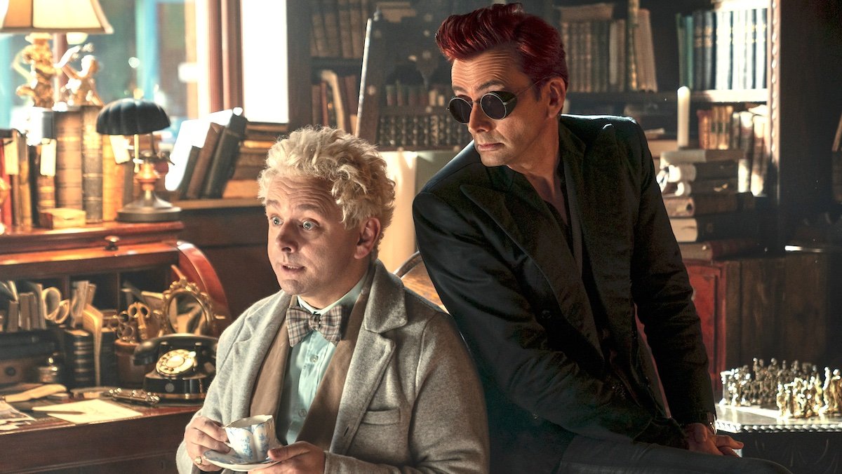 Aziraphale sitting in his chair with tea with Crowley sitting behind him on Good Omens