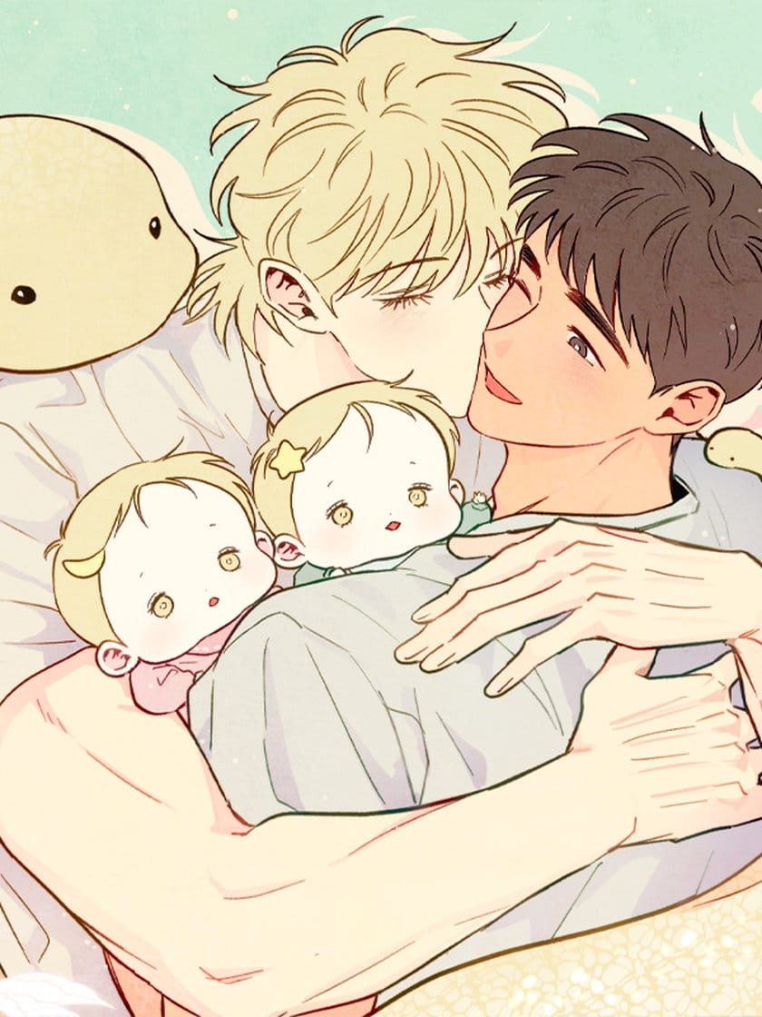 A blonde-haired man kisses a brown-haired man. The latter is holding two blonde babies.